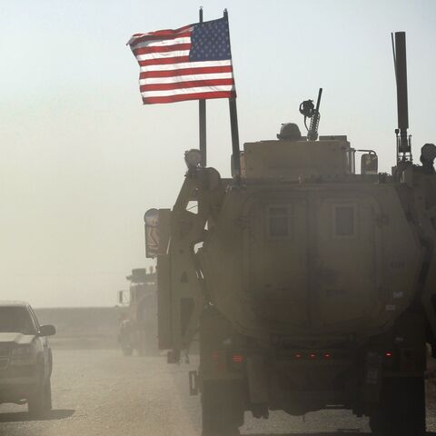 A US Army armored vehicle flies an American flag as it provides security escort for a convoy of vehicles pulling equipment that is heading to Kuwait from Camp Adder as the Army continues to send it's soldiers and equipment home and the base is prepared to be handed back to the Iraqi government later this month on December 2, 2011, at Camp Adder, near Nasiriyah, Iraq.